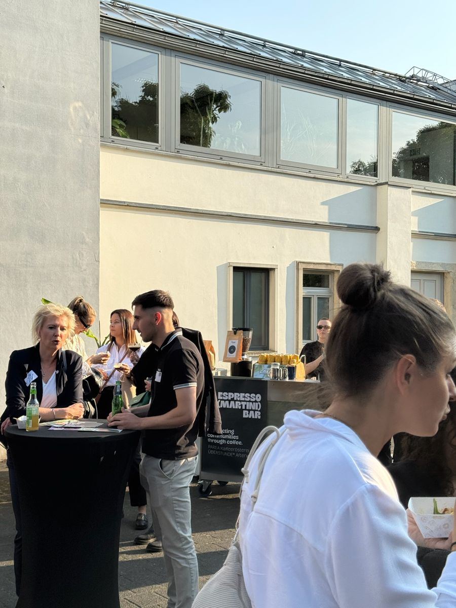 Gäste an Stehtischen neben der Espresso Bar