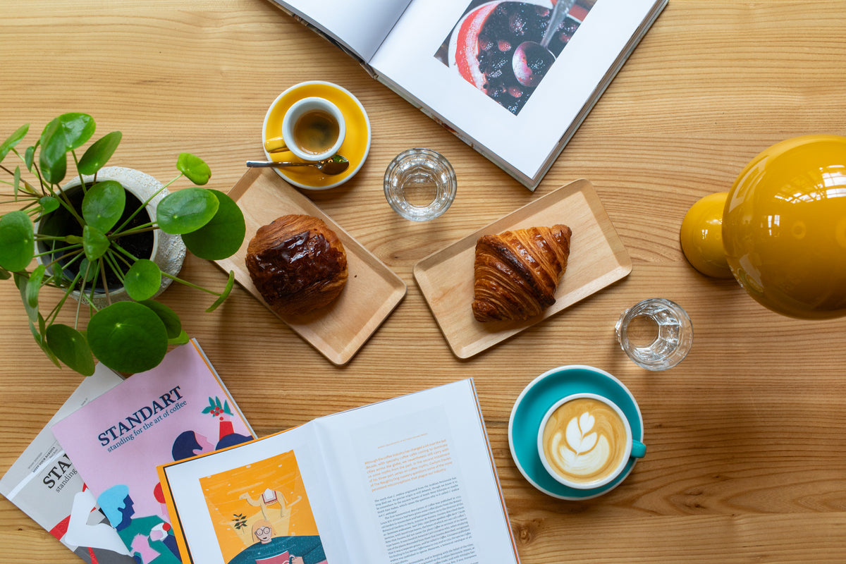 Espresso und Cappuccino mit Croissants auf einem Holztisch